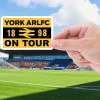 York city knights on tour sticker being held by a hand with the York Community Stadium in the background