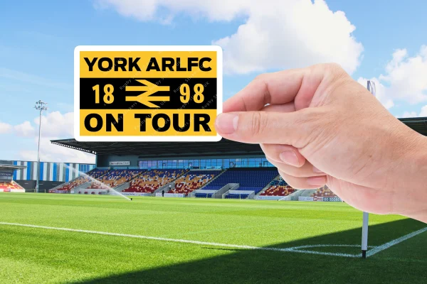 York city knights on tour sticker being held by a hand with the York Community Stadium in the background